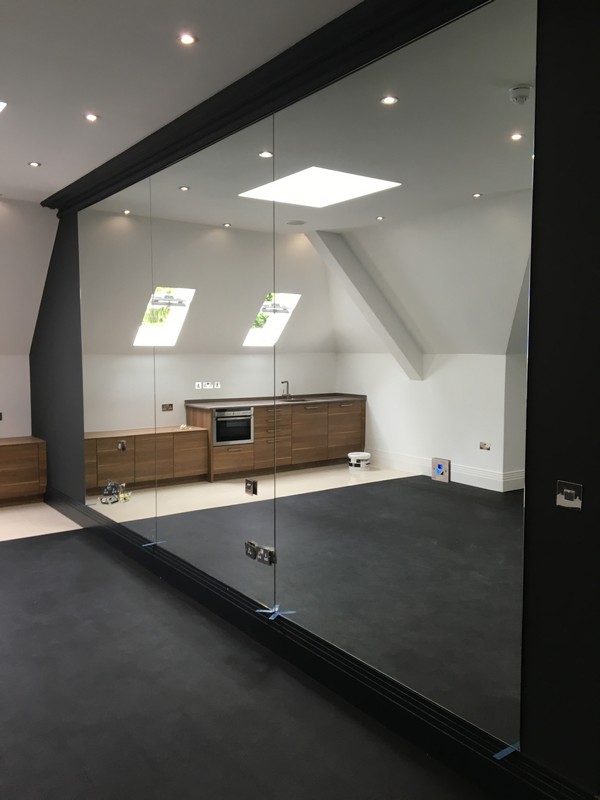 Frameless glass partition in loft conversion by Harlesden glaziers