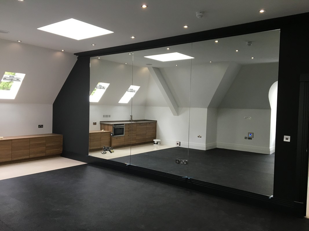 Frameless glass wall dividing loft conversion in Harlesden